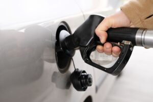 person fueling gassing up a car
